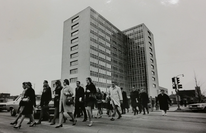 DSOB north view of building, black and white, with workers crossing the street